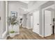 Bright entryway featuring light wood floors, white trim, and an decorative tree in a white pot at 5102 Tennis Ct, Las Vegas, NV 89120