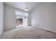 A bright bedroom with a vaulted ceiling, fan, neutral carpet, and sliding glass doors leading to the backyard at 5185 Briar Meadow Way, Las Vegas, NV 89118