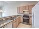 Kitchen with stainless steel appliances, light wood cabinets, and granite countertops at 5185 Briar Meadow Way, Las Vegas, NV 89118