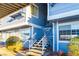 Exterior staircase leading to a blue apartment featuring lush shrubs and tasteful landscaping surrounding the property at 5330 Rod Ct # 202, Las Vegas, NV 89122