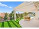 Backyard patio featuring a pergola, artificial grass, and a dining area with a view of the pool at 5520 Cranwood Ct, Las Vegas, NV 89130