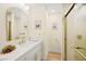 Bathroom featuring a stand-up shower with gold trim, a white vanity, and an arched mirror at 5520 Cranwood Ct, Las Vegas, NV 89130