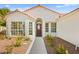 Welcoming front entrance with decorative windows, a red door, and manicured landscaping at 5520 Cranwood Ct, Las Vegas, NV 89130