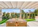 Outdoor patio seating area with a wooden table and chairs under a pergola at 5520 Cranwood Ct, Las Vegas, NV 89130