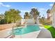 Backyard pool with a brick surround, grass, and landscaping at 5520 Cranwood Ct, Las Vegas, NV 89130