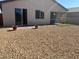 Low-maintenance backyard features gravel and covered patio with sliding door at 5980 E Drosetta Ave, Pahrump, NV 89061