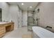 Modern bathroom featuring a soaking tub, frameless shower, and dual sink vanity at 6009 Silvalde Ln, Las Vegas, NV 89135