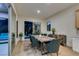 A cozy dining room with a wood table, blue chairs, and sliding doors to the backyard pool at 6009 Silvalde Ln, Las Vegas, NV 89135