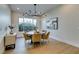 Elegant dining room with modern chandelier, and large windows overlooking lush greenery at 6009 Silvalde Ln, Las Vegas, NV 89135