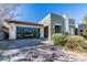 Contemporary home with a glass garage door, modern landscaping and neutral colored exterior at 6009 Silvalde Ln, Las Vegas, NV 89135