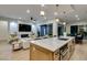 A spacious kitchen island with pendant lighting with a view into the living and dining rooms at 6009 Silvalde Ln, Las Vegas, NV 89135