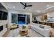 Bright living room with a white couch, ceiling fan, and sliding doors to the backyard pool at 6009 Silvalde Ln, Las Vegas, NV 89135