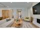 Living room with stone fireplace, TV, plush seating, and access to kitchen and hallway at 6009 Silvalde Ln, Las Vegas, NV 89135