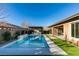 Backyard pool featuring a built-in water feature, turfed yard, and an outdoor kitchen at 6009 Silvalde Ln, Las Vegas, NV 89135