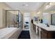 Modern bathroom with a double vanity, soaking tub, glass-enclosed shower, and access to the bedroom at 6021 Vista Clara St, Las Vegas, NV 89148