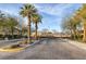 Gated community entrance with palm trees and well-maintained landscaping under a partly cloudy sky at 6021 Vista Clara St, Las Vegas, NV 89148