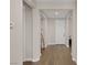 Clean and bright hallway featuring hardwood floors, neutral walls, and white trim leading to a white paneled door at 6021 Vista Clara St, Las Vegas, NV 89148