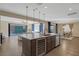 Spacious kitchen island with a beverage cooler, granite countertops, and a view of the living area and backyard with a pool at 6021 Vista Clara St, Las Vegas, NV 89148