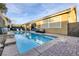 Backyard pool featuring tanning ledge, privacy landscaping, and a cozy seating area outside sliding glass doors at 6021 Vista Clara St, Las Vegas, NV 89148