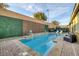 Inviting backyard pool with tanning ledge, seating areas, privacy wall with greenery, and brick-paved deck at 6021 Vista Clara St, Las Vegas, NV 89148