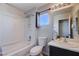 Bright bathroom with a shower-tub combo, light fixtures and a vanity with sink and accent mirror at 608 Breezy Sage Ct, Henderson, NV 89015