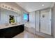 Bright bathroom with double sinks, separate shower, and soaking tub under a window at 608 Breezy Sage Ct, Henderson, NV 89015