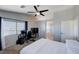 This bedroom features a ceiling fan, carpet, a work space with monitors, and access to a full bathroom at 608 Breezy Sage Ct, Henderson, NV 89015