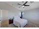 A cozy bedroom features a neutral color scheme, carpet, and comfortable bed with soft lighting from a ceiling fan at 608 Breezy Sage Ct, Henderson, NV 89015