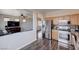 Well-lit kitchen boasts stainless steel appliances, wooden cabinets, stylish tile backsplash, and a modern gas range at 608 Breezy Sage Ct, Henderson, NV 89015