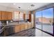 Well-lit kitchen with stainless steel appliances and dark wood floors with a patio view at 608 Breezy Sage Ct, Henderson, NV 89015