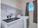 Featuring a modern washer and dryer and shelving, this laundry room is designed for convenience at 608 Breezy Sage Ct, Henderson, NV 89015