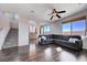 Bright living room with wood floors, ceiling fan, and staircase at 608 Breezy Sage Ct, Henderson, NV 89015