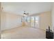 Large primary bedroom with carpet, ceiling fan, and a private balcony at 6337 Black Mane Way, North Las Vegas, NV 89081