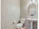 Elegant powder room featuring decorative wallpaper, a pedestal sink, and a toilet at 6337 Black Mane Way, North Las Vegas, NV 89081