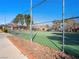 Well-maintained community tennis court with a green surface, surrounded by trees and landscaping at 6630 Bubbling Brook Dr # C, Las Vegas, NV 89107