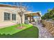 Brick-paved yard featuring covered patio and drought-resistant landscaping at 668 Look Lively Ct, Henderson, NV 89011