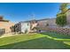 Manicured backyard featuring synthetic grass, low-maintenance landscaping, and storage shed at 668 Look Lively Ct, Henderson, NV 89011