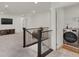 Bright hallway featuring a laundry room and wrought iron banister detail at 6988 Sylmar Ave, Las Vegas, NV 89113