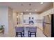 Contemporary kitchen with white cabinetry, stainless steel appliances, island with seating, and tile flooring at 720 Sleeping City Ave, Henderson, NV 89015