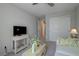 Bright sitting room features white sofa, side table and tv on a cabinet with carpet floors at 720 Sleeping City Ave, Henderson, NV 89015