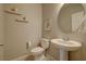 Well-lit powder room featuring a pedestal sink, toilet, neutral paint, and decorative wall shelves at 720 Sleeping City Ave, Henderson, NV 89015