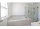 Bathroom features a tub, glass enclosed shower and window at 7400 Wheat Grass Ct, Las Vegas, NV 89129