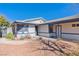 View of covered entry of well-maintained single-story home with desert landscaping in a residential neighborhood at 7436 Lattimore Dr, Las Vegas, NV 89128