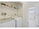 Functional laundry room with modern washer and dryer, and open shelving for organized storage at 7436 Lattimore Dr, Las Vegas, NV 89128