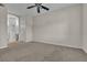 Carpeted bedroom with ceiling fan offers access to a bathroom and a door to the left at 7701 W Robindale Rd # 102, Las Vegas, NV 89113