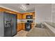 A well-lit kitchen with wooden cabinets, black appliances, and stone countertops at 7701 W Robindale Rd # 102, Las Vegas, NV 89113