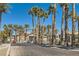 Gated community entrance lined with palm trees and lush landscaping with a well-paved road at 8000 W Badura Ave # 1019, Las Vegas, NV 89113