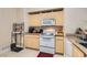 Functional kitchen featuring a white range, microwave, and light wood cabinets at 8000 W Badura Ave # 1019, Las Vegas, NV 89113
