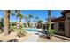 Community swimming pool with palm trees, lounge seating, and lush landscaping at 8000 W Badura Ave # 1019, Las Vegas, NV 89113