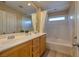 Bright bathroom features a double sink vanity and tiled shower and tub at 8234 Misty Sage St, Las Vegas, NV 89139